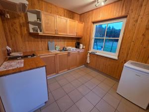 a kitchen with wooden cabinets and a white refrigerator at Lodja Jäägrimaja in Lodja