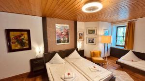 a living room with two beds in a room at Hotel-Landgasthof Grüner Baum - Dittigheim in Tauberbischofsheim