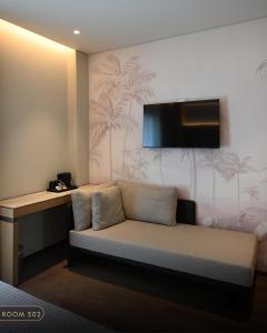 a room with a couch and a tv on a wall at Elmares Hotel in Himare