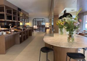 a kitchen with a counter with a vase of flowers at Hotel Medium Montecarlo in Llafranc +10 photos