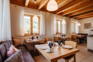 ein Esszimmer mit Tischen, Stühlen und Fenstern in der Unterkunft Gästehaus Lodermeier in Bad Abbach