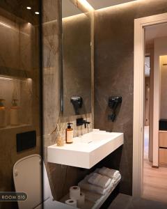 a bathroom with a white sink and a mirror at Elmares Hotel in Himare +93 photos