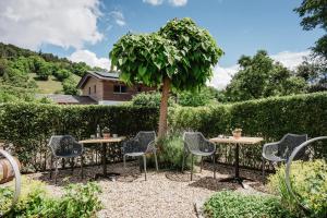 ein Garten mit Tischen und Stühlen und einem Baum in der Unterkunft Gästehaus Lodermeier in Bad Abbach
