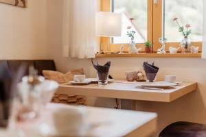 ein Esstisch mit Tellern und Tassen darauf in der Unterkunft Gästehaus Lodermeier in Bad Abbach + 16 Fotos