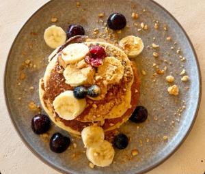 a plate of pancakes with bananas and berries at Zador Hotel in Ksamil