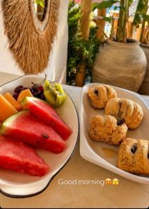 two plates of fruit and pastries on a table at Zador Hotel in Ksamil +23 photos