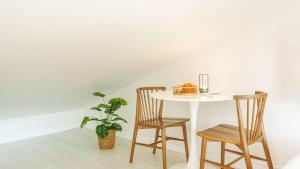 a white table with two chairs and a plant at Geoje Forest-Morning Spa Pension in Geoje +3 photos