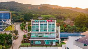 an aerial view of a building with mountains in the background at Geoje Forest-Morning Spa Pension in Geoje