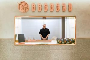 a man is standing in front of a mirror at Atour S Hotel Beijing Anzhen in Beijing