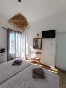 ein Schlafzimmer mit zwei Betten und einem Fernseher an der Wand in der Unterkunft Hotel Livadia in Parikia