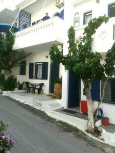 a house with a tree in front of it at Angelos Rooms in Myrtos