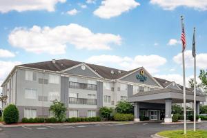 an exterior view of a hotel with an american flag at Quality Suites Pineville - Charlotte in Charlotte