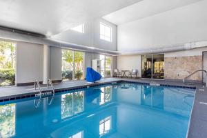a swimming pool with blue water in a building at Quality Suites Pineville - Charlotte in Charlotte