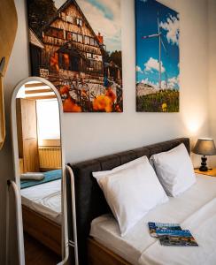 a room with a bed and a picture of a house at Hostel Nikšić in Nikšić