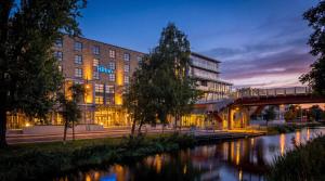 a building next to a river with a bridge at Hilton Dublin in Dublin