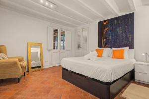 a bedroom with a bed and a mirror and a chair at Casa Elegante in Vilanova i la Geltrú