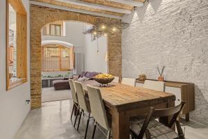 a kitchen and dining room with a wooden table and chairs at Casa Elegante in Vilanova i la Geltrú +19 photos