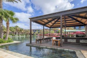 a pool at a resort with tables and chairs at Hilton Cabo Verde Sal Resort in Santa Maria