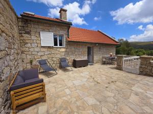 a stone building with chairs and a patio at Refúgio do Zé Espanhol in Arcos de Valdevez