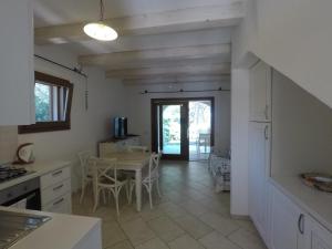 a kitchen with a table and a dining room at La Corte Degli Ulivi Appartamenti in Cala Liberotto