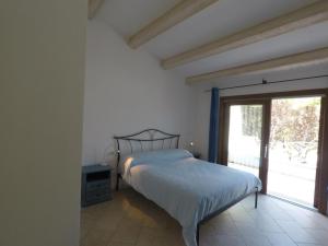 a bedroom with a bed and a large window at La Corte Degli Ulivi Appartamenti in Cala Liberotto