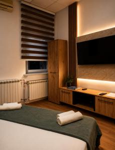 a bedroom with a bed and a flat screen tv at Hostel Nikšić in Nikšić