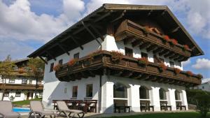 a white building with a balcony with flowers on it at Feriendorf Hauzenberg-Pool&Sauna in Hauzenberg