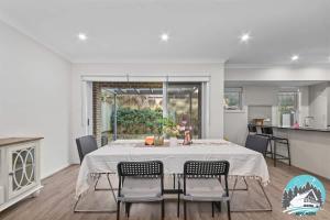 a kitchen and dining room with a table and chairs at Spacious 4BR Yard Retreat in Kellyville