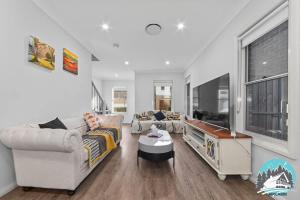 a living room with two couches and a tv at Spacious 4BR Yard Retreat in Kellyville +6 photos