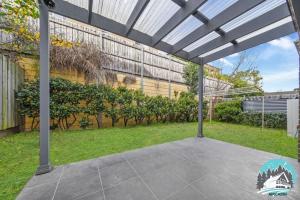 an outdoor patio with a pergola and grass at Spacious 4BR Yard Retreat in Kellyville