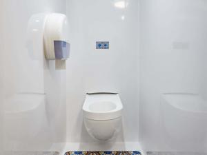 a white bathroom with a toilet and a phone at HôtelF1 Angoulême in Champniers