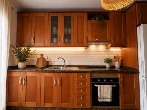 a kitchen with wooden cabinets and a sink at VV Vista a Teno in Buenavista del Norte