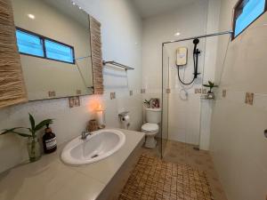 a bathroom with a sink and a toilet at Thong Sala Japandi Villa in Thong Sala