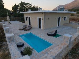 a house with a swimming pool next to a building at Vakontas Luxury Stay in Gerolimenas