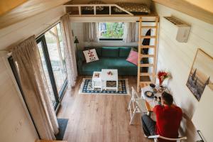 a man sitting at a table in a tiny house at Jemiołucha Glamping in Bodzentyn