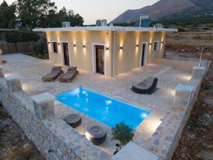 a swimming pool in front of a house at Vakontas Luxury Stay in Gerolimenas
