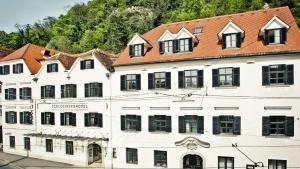 a large white building with a red roof at Schlossberghotel in Graz