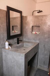 a bathroom with a concrete sink and a mirror at Seagreen Guesthouse - Galle Fort in Galle