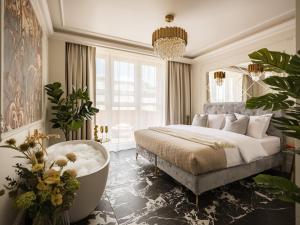 a bedroom with a large bed and a bath tub at Feniks Main Square by Fragola Collection in Krakow