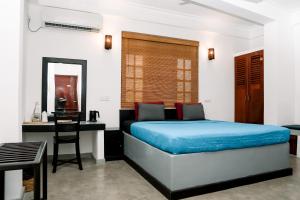 a bedroom with a bed and a desk at Seagreen Guesthouse - Galle Fort in Galle