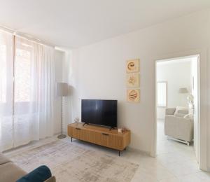a living room with a flat screen tv and a couch at Ca del Mar Venice Luxury Apartments in Venice