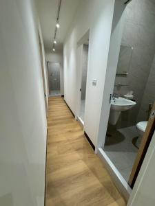 a hallway of a bathroom with a sink and a toilet at 滸衖海旅 in Anping