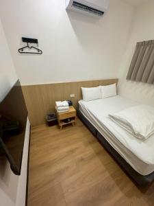 a small bedroom with a bed and a night stand at 滸衖海旅 in Anping