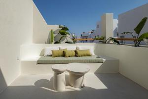 a bench on top of a balcony with a stool at Naxia Gaia Suites in Agia Anna Naxos