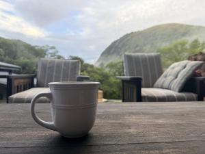 a white coffee cup sitting on a wooden table at Seldom Seen in Malelane