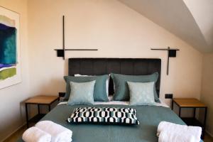 a bedroom with a large green bed with two side tables at Luminosa Collection - Casa Celeste in Razáta