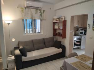 a living room with a couch and a kitchen at Casita La Playa in Málaga