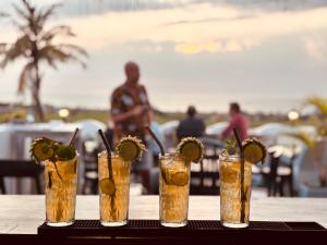 a table with four cocktails with lime slices in them at Seagreen Guesthouse - Galle Fort in Galle