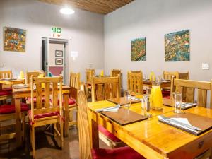 a dining room with wooden tables and chairs at Goedgedacht Farm in Malmesbury