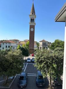 a clock tower with cars parked in a parking lot at Big Brother Bed & Rooms in Treviso